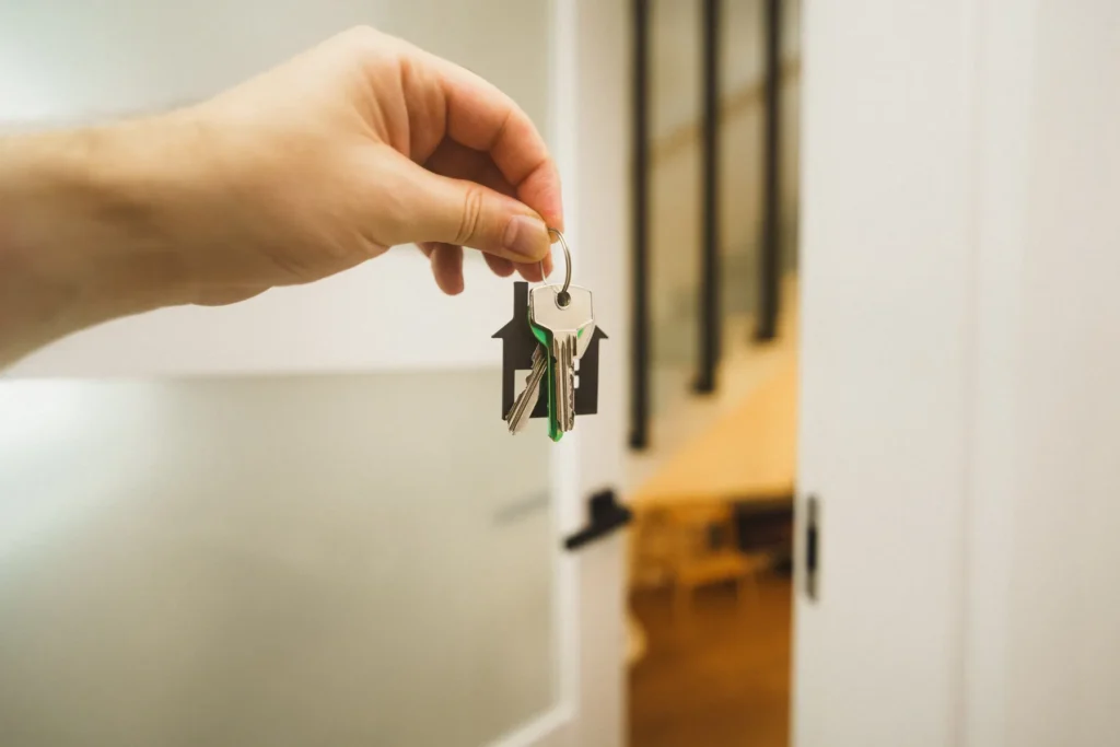 A hand holding a home key in a bright interior