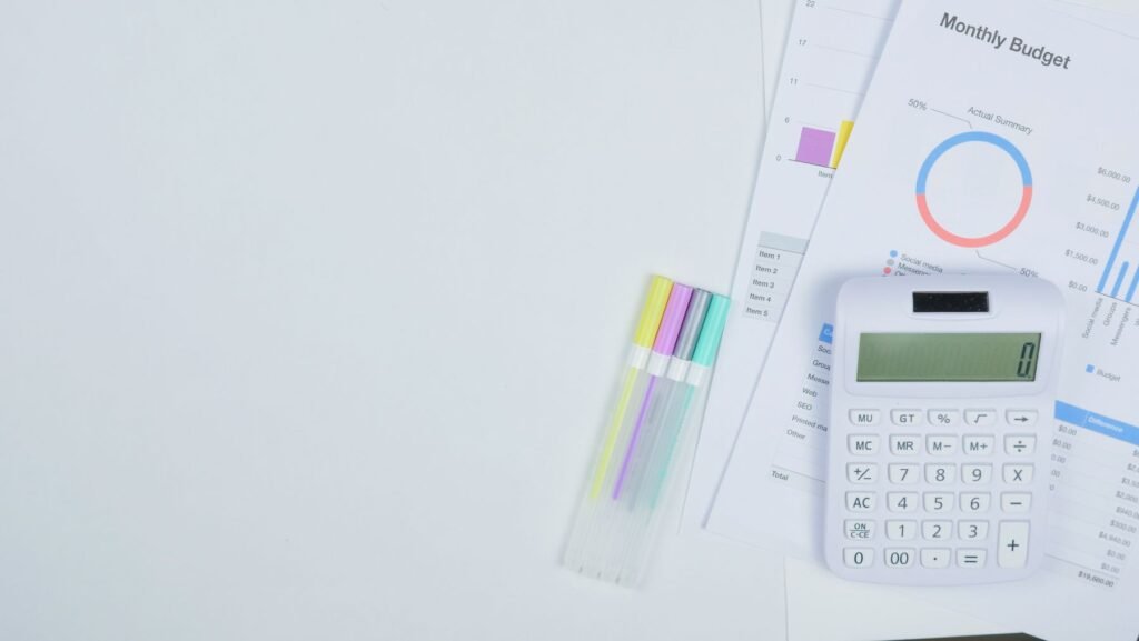 Calculator, planning documents and pens arranged on a desk