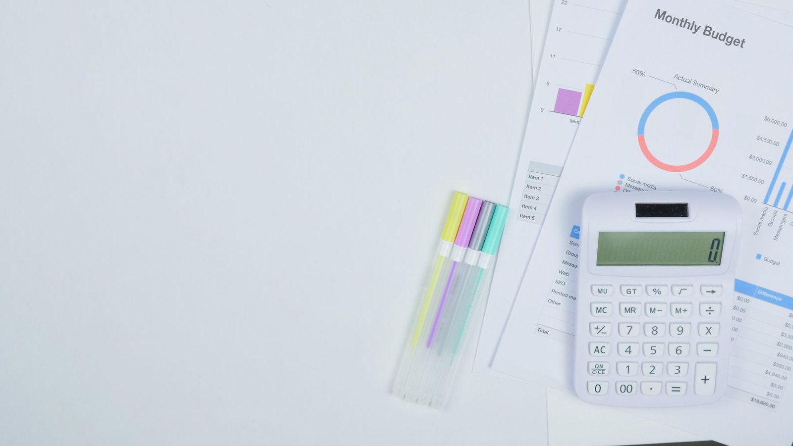 Calculator, planning documents and pens arranged on a desk
